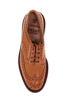 The Bourton derby lace-up shoes by Tricker's are made of antiqued Acorn leather with brogue punching and a gusseted tongue sewn to the shoe. The lining is full-grain leather, while the insole features padded heel support. They have a Goodyear construction with waterproof stitching, a full-grain leather midsole with cork padding, and a studded Dainite rubber sole. Composition: 100% calfskin Classic Wingtip Lace-up Shoes With Leather Lining, Brown Goodyear Welted Lace-up Derby Shoes, Brown Brogue Lace-up Shoes With Moc Toe, Timeless Leather Lace-up Shoes With Brogue Detailing, Timeless Brown Lace-up Shoes With Rubber Sole, Classic Wingtip Lace-up Shoes For Derby, Wingtip Lace-up Shoes With Leather Lining For Work, Classic Wingtip Lace-up Shoes With Stitched Sole, Timeless Brown Wingtip Derby Shoes