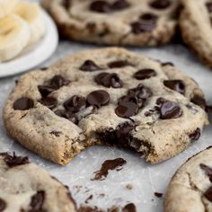 chocolate chip cookies are cut in half and placed on a baking sheet next to bananas