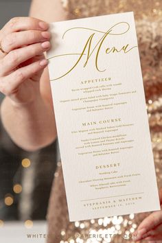 a close up of a person holding a menu card in front of a table with gold sequins