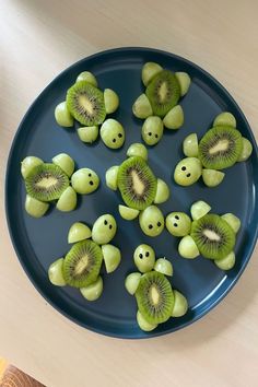 sliced kiwis arranged in the shape of smiley faces on a blue plate