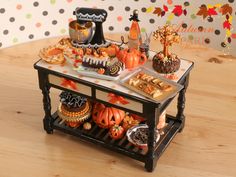 a table topped with lots of desserts on top of a wooden floor next to a polka dot wall