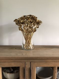 a vase filled with dried flowers sitting on top of a wooden table