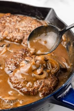 a ladle scooping some food out of a skillet with meat and mushrooms in gravy