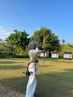 a man is practicing his archery skills in the park