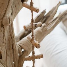 a bed with driftwood sticks hanging from it's headboard and pillows in the background