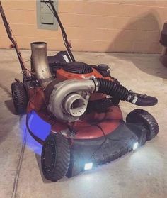 a lawn mower sitting on the ground with its lights on