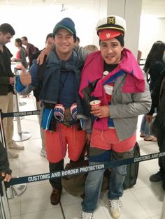 two people standing next to each other at an airport