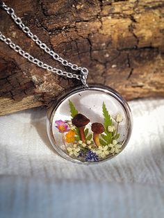 Wear the tranquil beauty of a woodland walk with this enchanting terrarium necklace. Real mushrooms, delicate wildflowers, and fern leaves are forever preserved in crystal-clear eco-resin, creating a miniature forest dreamscape to wear close to your heart.  This whimsical piece is ideal for nature lovers, cottagecore enthusiasts, and anyone seeking a touch of fairytale charm.  🍄 This magical necklace is made of a metal alloy that is hypoallergenic and anti-tarnish, making it suitable for those Miniature Forest, Pressed Wildflowers, Cottagecore Necklace, Real Mushrooms, Magical Necklace, Mushroom Cottagecore, Woodland Walk, Terrarium Necklace, Fern Leaves