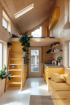 the interior of a tiny house with stairs leading up to the loft bed and kitchen