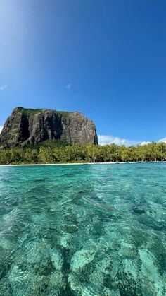 an island in the middle of clear blue water