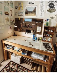 a workbench with lots of crafting supplies on the table and pictures on the wall behind it