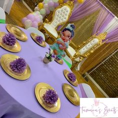 there is a purple table with gold plates on it and some balloons in the background