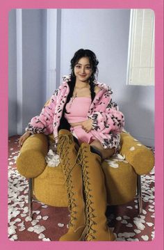 a woman sitting in a chair wearing boots