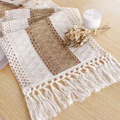 a table topped with a white and brown blanket next to a glass of milk