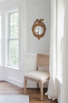 a chair and mirror in a white room