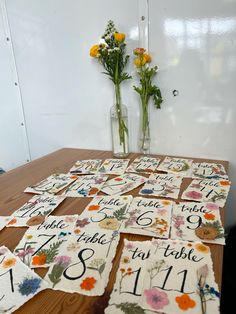 the table is covered with flowers and place cards for each individual to write their names