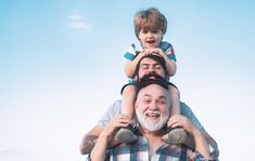 an older man holding a young boy on his shoulders