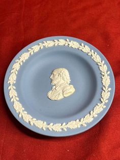 a blue and white plate with an image of a man's head on it