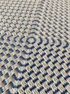 a close up view of the blue and white knitted fabric on a tablecloth