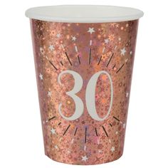 a pink and gold cup with the number 30 printed on it's side, in front of a white background