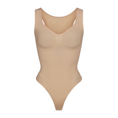 This scoop neck sculpting thong bodysuit enhances your natural shape while defining and smoothing your waist, core, tummy, and back. Features thick non-adjustable straps, center front and side stitching to define and support your bust, and a cotton gusset with snap closure. Fits true to size. | SKIMS Scoop Neck Thong Bodysuit | Light Neutral | Seamless Sculpt Women's Shapewear, Natural Shapes, Black Bodysuit, Black Media, Shapewear, Scoop Neck, Lounge Wear, How To Wear