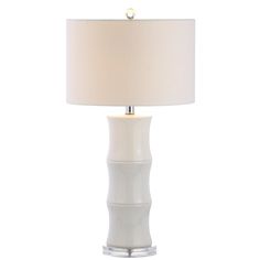 a white table lamp with a beige shade