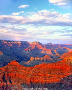 the sun is setting at the grand canyons in the desert with blue sky and white clouds