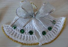 a white and gold brooch with green beads