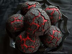 a bunch of black and red cookies in a metal bowl