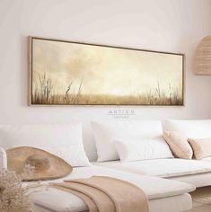 a white couch sitting under a painting on the wall