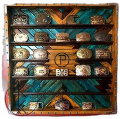 a wooden shelf filled with lots of different types of belt buckles on top of each other