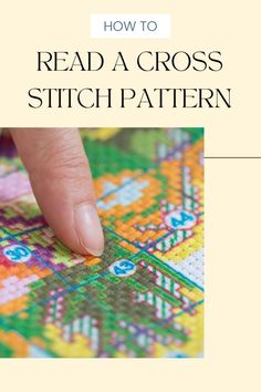 a hand is touching the cross stitch pattern on a piece of fabric with text overlay