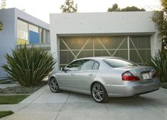 a silver car parked in front of a garage