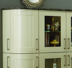 a white cabinet with glass doors and a clock above it on the wall behind it