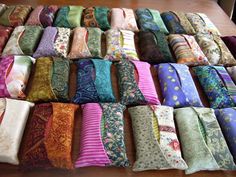 many different types of ties laid out on a wooden table with one folded in the middle