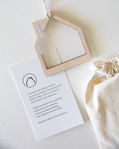 a wooden house ornament next to a paper bag with a poem on it