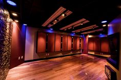 an empty room with wooden floors and red lockers on the walls, lights in the ceiling