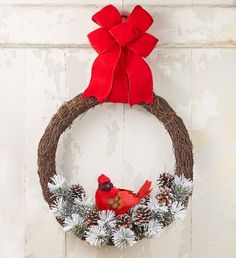 a wreath with a cardinal and pine cones on it