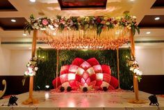 an elaborately decorated stage set up for a wedding ceremony with red and white flowers