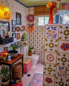 a colorful bathroom with lots of decorations on the walls and floor, including a toilet