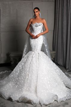 a woman in a white wedding dress with a veil on her head