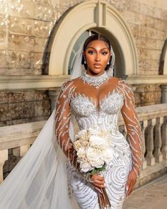 a woman in a wedding dress and veil posing for the camera with flowers on her bouquet