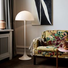 a living room scene with focus on the floor lamp and couch in the foreground