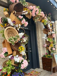 flowers and baskets decorate the front door of a flower shop