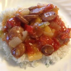 a white plate topped with rice and meat covered in sauce