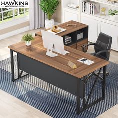 a computer desk with a laptop on top of it next to a chair and bookshelf