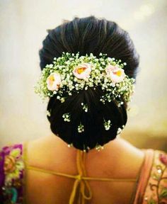 the back of a woman's head with flowers in her hair