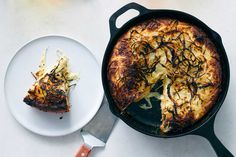 a pizza sitting on top of a pan next to a white plate