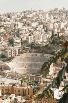 an aerial view of a city with lots of buildings in the foreground and trees in the foreground