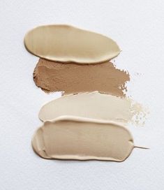 three different shades of foundation on a white surface